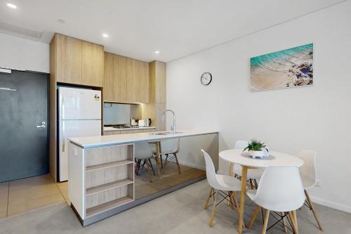 a kitchen with a counter and a table and chairs at Urban Luxe Retreat - South Brisbane Boutique Apt w Free Carpark in Brisbane