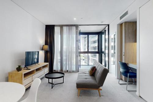 a living room with a couch and a tv at Urban Luxe Retreat - South Brisbane Boutique Apt w Free Carpark in Brisbane