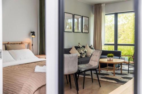 a bedroom with a bed and a couch and a table at Šventosios uostas in Palanga