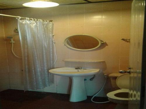 a bathroom with a sink and a toilet and a mirror at Hug Glur House Tour and Hostel in Chiang Mai