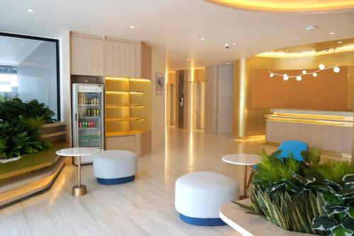 a lobby with two tables and two blue chairs at Wyndham Garden Naithon Phuket in Nai Thon Beach