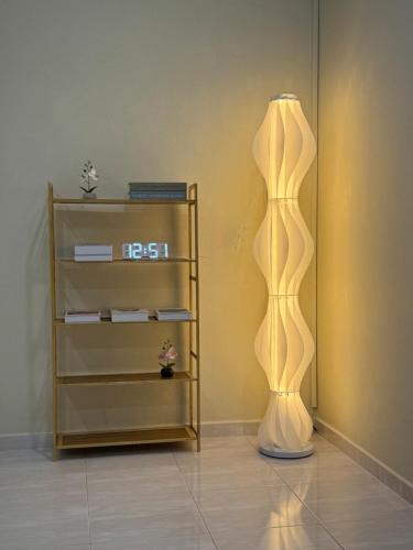 a lamp in a room next to a shelf at Modern and Cozy home in the heart of Segamat in Segamat