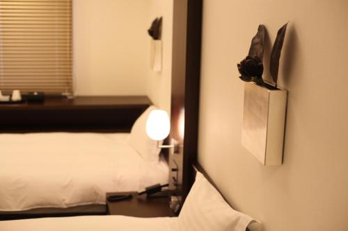 a hotel room with a mirror and a bed at Furano Natulux Hotel in Furano