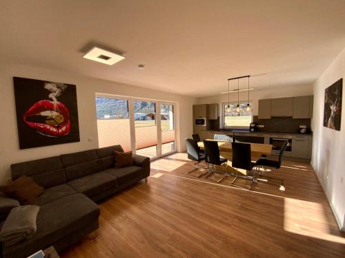 a living room with a couch and a table and chairs at Apartment Deluxe mit Whirlpool und Fasssauna in Imsterberg