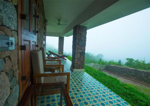 a room with a balcony with a view of a road at Anudhyana Premium Private Stone Villa Vagamon by VOYE HOMES in Vagamon