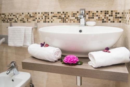 a bathroom with a sink and towels on a shelf at Domus Trevi in Rome