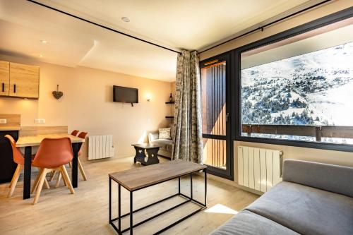 un salon avec un canapé et une table dans l'établissement Appartement 4 personnes pied des pistes, à Les Allues