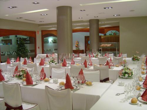 a banquet hall with white tables and red napkins on them at Brea's Hotel in Reus