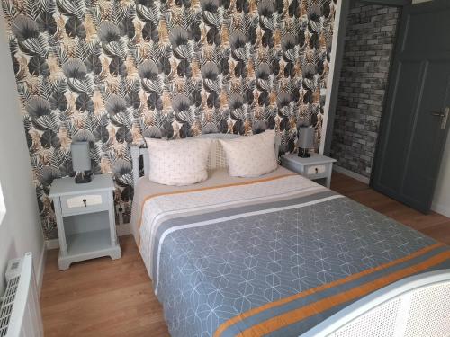 a bedroom with a bed and a wall with plants at Appartement cosy in Charleville-Mézières