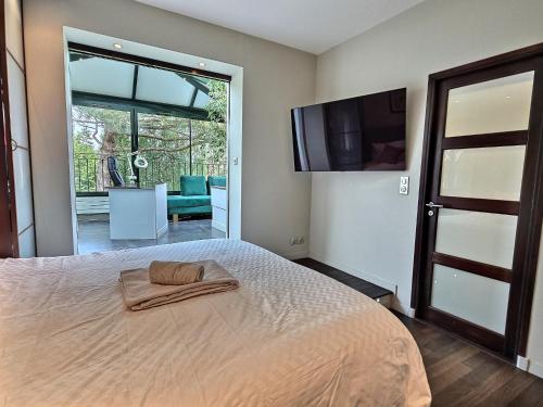 une chambre avec un lit et une télévision à écran plat dans l'établissement Magnifique Villa, Piscine, Paris à 15 min, Parking, à Sèvres