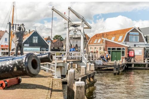 a dock with a boat in the water next to houses at Bed & Breakfast De Punt in Monnickendam
