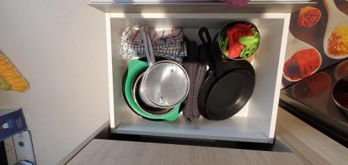a white cabinet with utensils and pans in it at Luxury 32nd Floor 2 Bed-2 Bath Apartment with Pool, Harbour & Lotus Tower views in Colombo