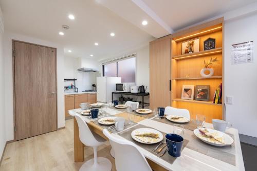 a dining room with a long table and white chairs at Y's INN 駒込 110T in Tokyo