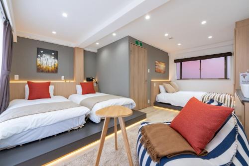 a room with two beds and a chair in it at Y's INN 駒込 110T in Tokyo