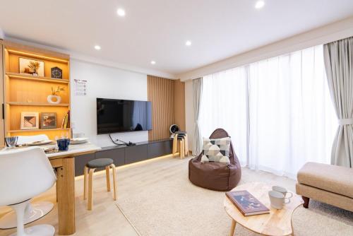 a living room with a television and a couch and a table at Y's INN 駒込 110T in Tokyo