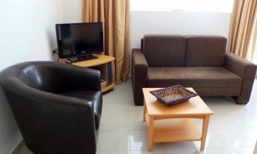 a living room with a couch and a chair and a table at Lagada Resort in Makry Gialos