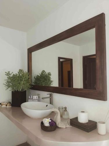 a bathroom with a sink and a large mirror at Villa Kalachuchi V.K in Puerto Princesa City