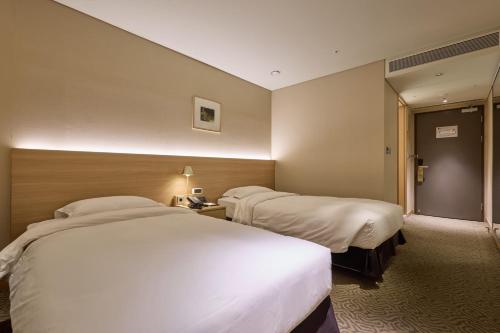 a hotel room with two beds and a hallway at Summit Hotel Seoul Dongdaemun in Seoul