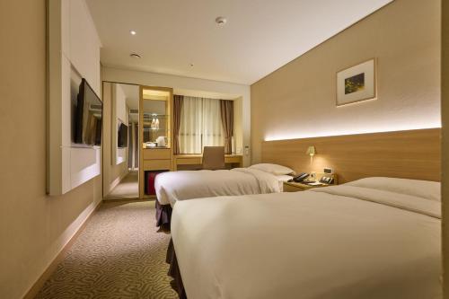 a hotel room with two beds and a television at Summit Hotel Seoul Dongdaemun in Seoul