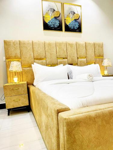a bedroom with a large bed with a large headboard at Sn suites apartments in Kampala