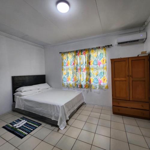 a small bedroom with a bed and a window at Wane's BnB in Nadi