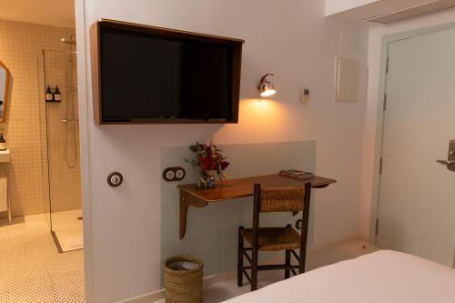 a bedroom with a desk and a television on a wall at Hotel du Temps Madrid in Madrid