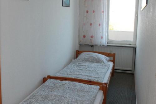 due letti in una piccola stanza con una finestra di Ferienwohnung F334 für 2-4 Personen an der Ostsee a Schönberg in Holstein