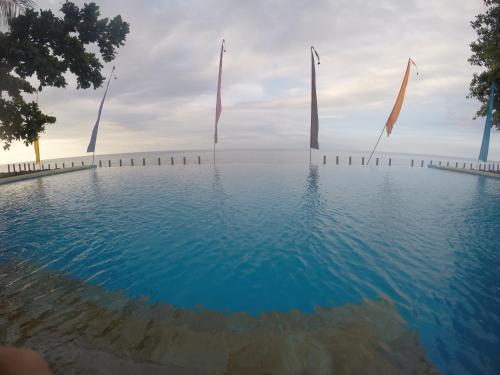 a swimming pool with flags in the water at Ritinula Resort in Tejakula