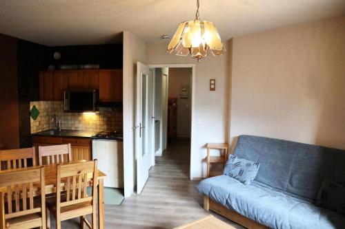 un salon avec un canapé bleu et une cuisine dans l'établissement Résidence Orr Des Cimes - Orrianes des Cimes 412 MAE-3804, à Le Mélézet