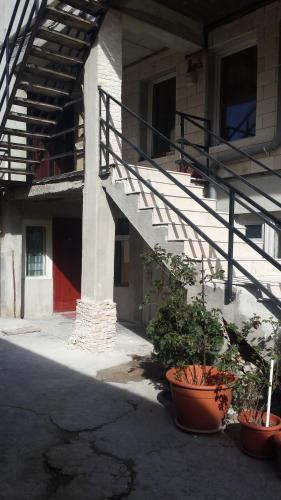 a building with stairs and potted plants in front of it at Csikos Apartment in Cluj-Napoca