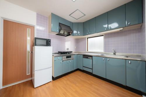 a kitchen with blue cabinets and a white refrigerator at Casa GS Osaka Port in Osaka