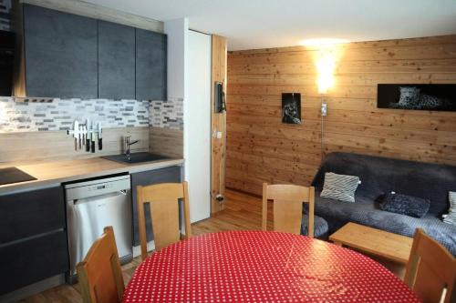 une cuisine et une salle à manger avec une table et des chaises rouges dans l'établissement Les Chalets De Bois Mean - A223 LES BALCONS DE BOIS MEAN : Résidence de standing MAE-0434, aux Orres