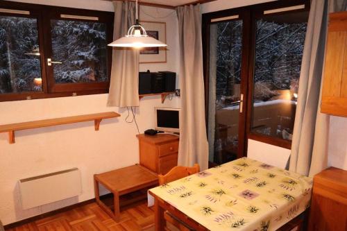 Cette petite chambre comprend une table, un bureau et une fenêtre. dans l'établissement Résidence Le Meale - CENTRE-STATION Les Orres 1650 - Rés. MEALE - Studio 4 personnes MAE-3891, aux Orres