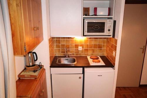 une petite cuisine avec un évier et un micro-ondes dans l'établissement Résidence Le Meale - CENTRE-STATION Les Orres 1650 - Rés. MEALE - Studio 4 personnes MAE-3891, aux Orres