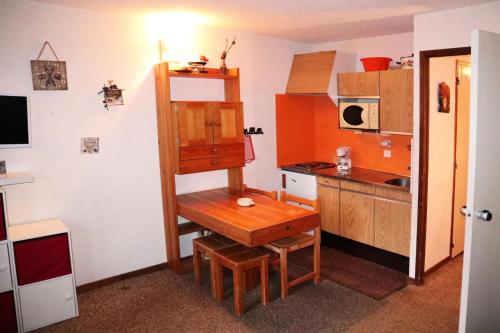 une petite cuisine avec une table en bois dans une pièce dans l'établissement Résidence Le Pouzenc - Studio calme pieds de pistes MAE-3911, aux Orres