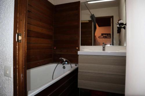 une salle de bain avec une baignoire, un lavabo et un miroir dans l'établissement Résidence Le Pouzenc - Studio calme pieds de pistes MAE-3911, aux Orres