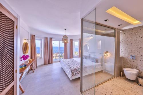 a bedroom with a bed and a glass wall at Villa Melissa Kaş Peninsula in Kaş