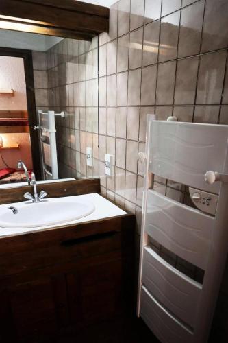 une salle de bain avec un lavabo et un miroir dans l'établissement Résidence Le Cairn - CENTRE STATION APPARTEMENT 307 CAIRN MAE-6301, aux Orres