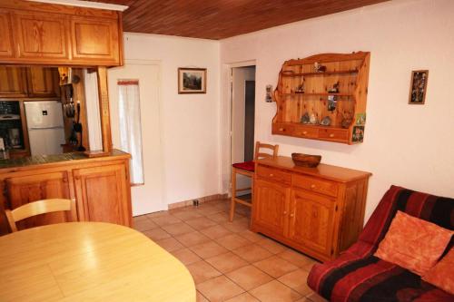 une cuisine avec des placards en bois, une table et un comptoir dans l'établissement Résidence L'horizon - COEUR DE STATION Les Orres 1650 - Rés. L'HORIZON - Appart T2 6 Pers. MAE-6621, aux Orres