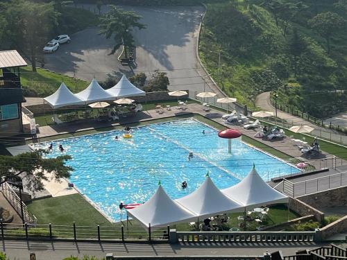 an overhead view of a large swimming pool with white umbrellas at Nine Valley Park in Boeun