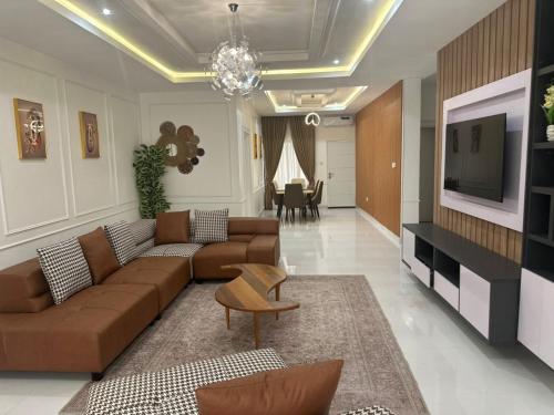 Una sala de estar con un sofá y un televisor. en Savvy Residences, en Abuja