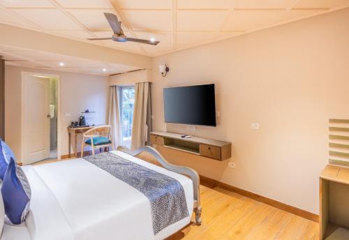 a bedroom with a bed and a flat screen tv at Goan Bliss in Varca
