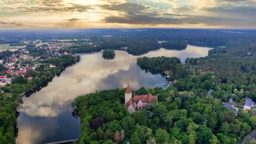 an island in a lake with a castle in the middle at Całoroczny Domek Hampton Lubniewice, jezioro, jacuzzi in Lubniewice