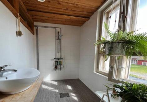 a bathroom with a white sink and two windows at Kuohuvirran kartano in Nummistenkylä