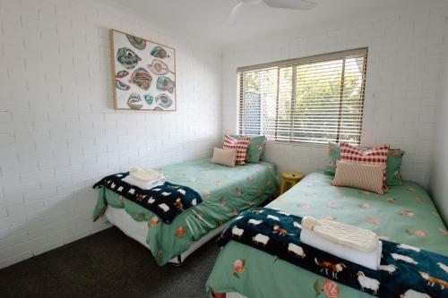 a room with two twin beds and a window at Luxe Farmstay, Main House and Brand New Tiny Home, Animals and Views! in Obi Obi