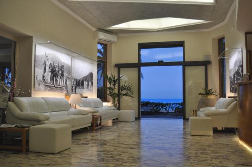 a living room with white furniture and a large window at Hotel Boncardo in Finale Ligure