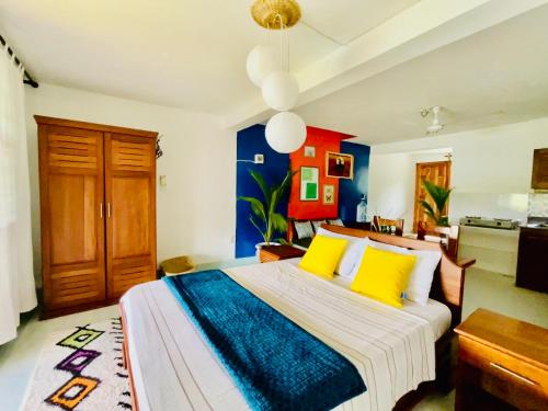Un dormitorio con una cama grande con almohadas amarillas. en Su Casa - Ocean View, Remote Work Friendly, en Kilifi