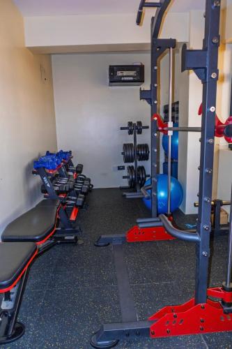 a gym with several tread machines in a room at Homey Haven in Juja