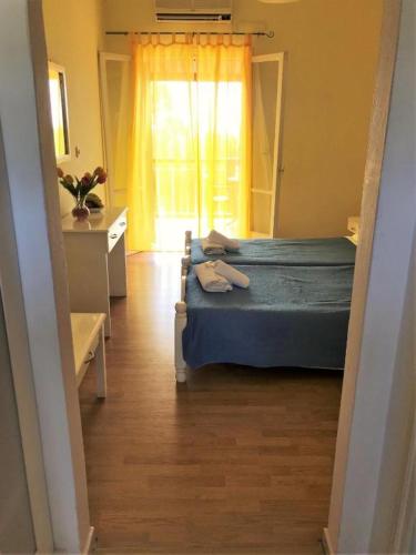 a bedroom with two beds and a window at Firefly Studios Panayiota 16 in Moraitika
