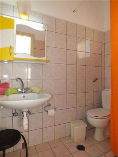 a bathroom with a sink and a toilet and a mirror at Firefly Studios Panayiota 16 in Moraitika